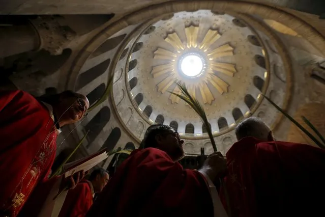 Members of the clergy hold palm fronds as they take part in a Palm Sunday procession at the Church of the Holy Sepulchre in Jerusalem's Old City March 20, 2016. (Photo by Amir Cohen/Reuters)