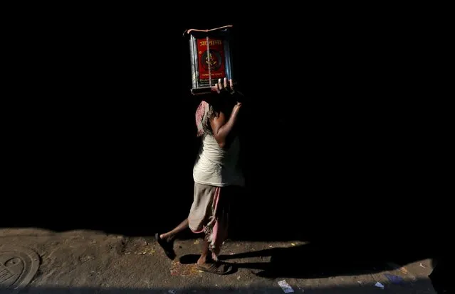 Jojinder Yadav, 38, carries a filled cooking oil tin to load it on a truck in Kolkata, India, March 9, 2016. (Photo by Rupak De Chowdhuri/Reuters)