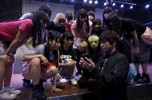 Producer Masaki Nagata (front R) and members of Japanese idol group Kamen Joshi (Masked Girls) talk during a rehearsal for their concert at their theatre in Tokyo's Akihabara district, Japan March 17, 2016. (Photo by Toru Hanai/Reuters)