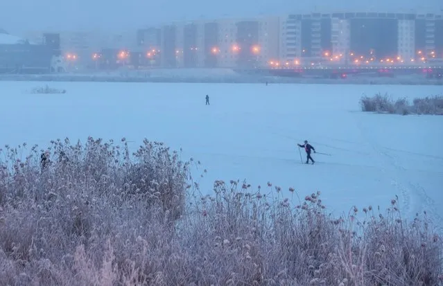 A man skis across frozen Lake Saisary in Yakutsk, the capital of the Sakha Republic (Yakutia) in the Russian Far East on November 22, 2021. Located in Tuimaada Valley on the Lena River, Yakutsk is the largest city in the permafrost zone. On 22 November 2021, the daytime temperature reached –34 degrees Celsius in Yakutsk. (Photo by Vadim Skryabin/TASS)