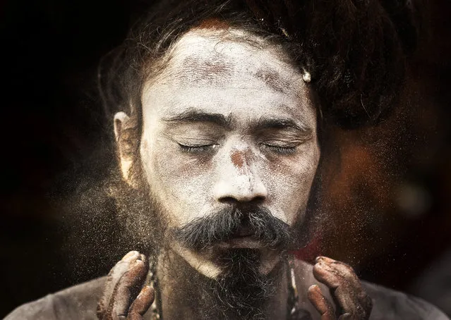 An Indian Sadhu, or Hindu holy man, smears sacred ash on his face at the Kamakhya Hindu temple ahead of the Ambubachi festival in Gauhati, India, Friday, June 21, 2019. The festival is held in celebration of the annual menstrual cycle of the Goddess Shakti at the Kamakhya Temple. the four-day festival will begin Saturday. (Photo by Anupam Nath/AP Photo)