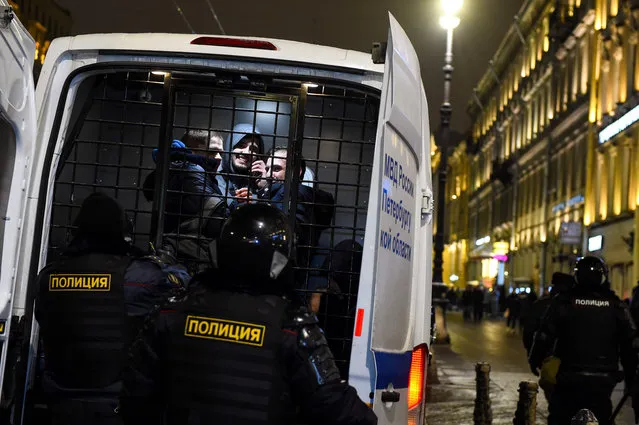 Detained men are seen in a police vehicle during a protest against a court ruling ordered Russian opposition leader Alexei Navalny jailed for nearly three years, in downtown Saint Petersburg on February 2, 2021. (Photo by Olga Maltseva/AFP Photo)