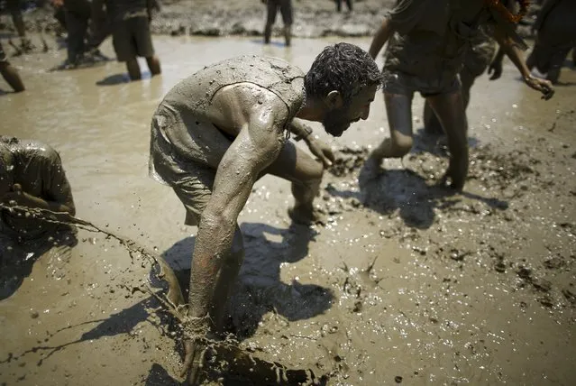 A tourist tries to dodge a mud during the Asar Pandhra festival in Pokhara valley, west of Nepal's capital Kathmandu, June 30, 2015. (Photo by Navesh Chitrakar/Reuters)