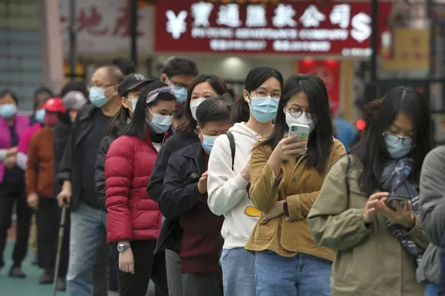 Residents line up to get tested for the coronavirus at a temporary testing center for COVID-19 in Hong Kong, Wednesday, February 9, 2022. Hong Kong's leader announced on Tuesday the city's toughest social-distancing restrictions yet, including unprecedented limits on private gatherings, as new daily cases surge above 600. (Photo by Kin Cheung/AP Photo)