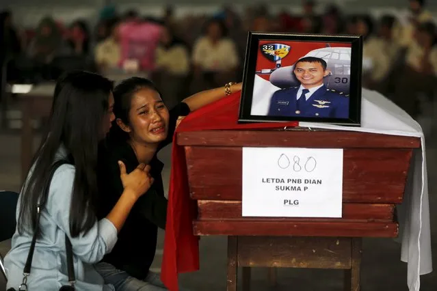A woman cries beside the coffin of her husband, who is a victim of an Indonesian military C-130 Hercules transport plane that crashed into a residential area, inside military airbase in Medan, North Sumatra province, Indonesia July 1, 2015. (Photo by Reuters/Beawiharta)