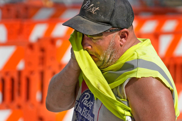 Jeff Nerby, with Arrow-Crete Construction, wipes away the sweat on a hot and humid day while working on a project involving a bump out for a bike path car the corner of East Well Street in North Milwaukee Street in Milwaukee, Wisconsin, U.S. June 17, 2024. (Photo by Mike De Sisti/The Milwaukee Journal Sentinel via USA Today Network)