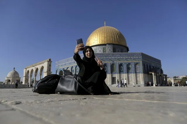 Palestinian Nura Hassan, 17, from the West Bank town of Bethlehem, takes a selfie photo in front of the Dome of the Rock on the compound known to Muslims as Noble Sanctuary and to Jews as Temple Mount, in Jerusalem's Old City, during the holy month of Ramadan, June 29, 2015. (Photo by Ammar Awad/Reuters)