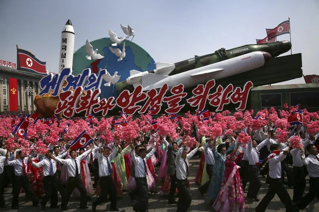 In this Saturday, April 15, 2017 file photo, North Korean men and women wave flags and plastic flowers as a float with model missiles and rockets with words that read “For Peace and Stability in the World” is paraded across Kim Il Sung Square during a military parade in Pyongyang. North Korea on Sunday, April 16, failed in a missile launch from its eastern coast, South Korea's Joint Chiefs of Staff said, but it wasn't immediately clear what kind of missile was fired. The launch from the city of Sinpo comes a day after one of the biggest North Korean propaganda events of the year – celebrations of the 105th birthday of late North Korea founder Kim Il Sung, the current leader's grandfather. (Photo by Wong Maye-E/AP Photo)