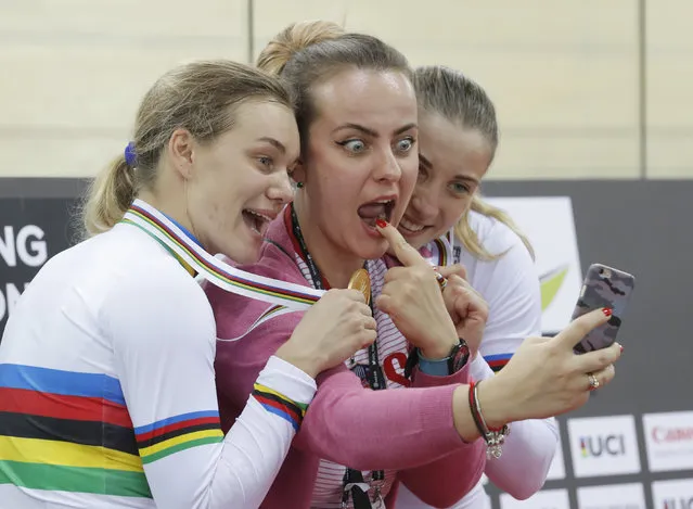 Russia's Anastasiia Voinova, left, and Daria Shmeleva pose for a selfie with an unidentified woman after winning the gold medal in the Women's Team Sprint at the World Track Cycling championships in Hong Kong, Wednesday, April 12, 2017. (Photo by Kin Cheung/AP Photo)