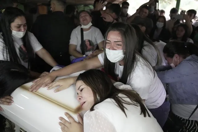 Relatives of Leidy Vanessa Luna Villalba mourn over her coffin during a wake at her home in Eugenio Garay, Paraguay, Tuesday, July 13, 2021. The nanny employed by the sister of Paraguay's first lady Silvana Lopez Moreira was among those who died in the Champlain Towers South condominium collapse in Surfside, Florida on June 24. (Photo by Jorge Saenz/AP Photo)