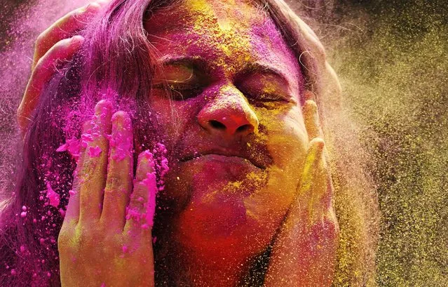 Colored powder is smeared on the face of a reveller during celebration marking Holi, the Hindu festival of colors, in Mumbai, India, Friday, March 18, 2022. (Photo by Rajanish Kakade/AP Photo)