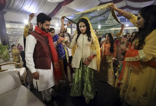 Hafiz Mohammad Awais, groom, left, and bride Musfira Shams, center, attend during their wedding ceremony in Rawalpindi, Islamabad, Pakistan, Wednesday, March 16, 2022. (Photo by Rahmat Gul/AP Photo)