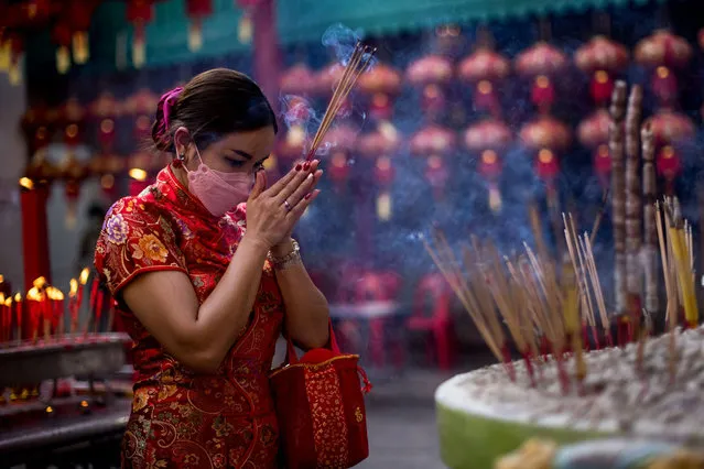 A woman prays at a shrine to mark the start of the Lunar New Year of the Tiger in Bangkok on February 1, 2022. (Photo by Jack Taylor/AFP Photo)