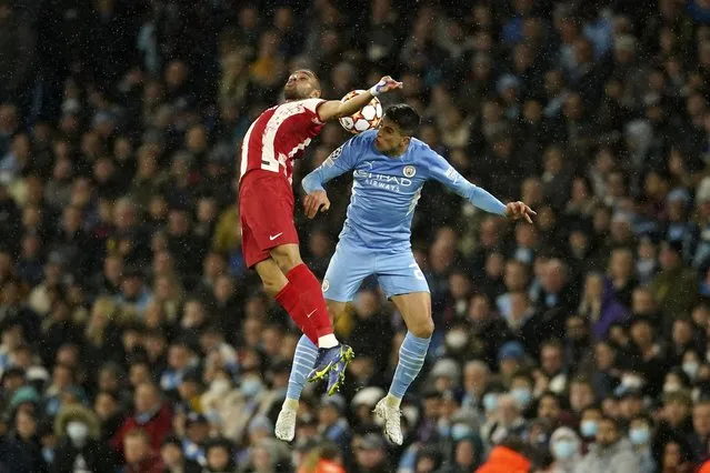 Atletico Madrid's Renan Lodi, left, jumps for the ball with Manchester City's Joao Cancelo during the Champions League, first leg, quarterfinal soccer match between Manchester City and Atletico Madrid at the Etihad Stadium, in Manchester, Tuesday, April 5, 2022. (Photo by Dave Thompson/AP Photo)