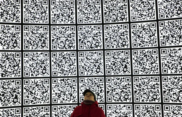 A woman looks at a wall with QAR Codes visiting the Zaryadye museum in a new park next to the Kremlin and Red Square in Moscow, Russia, 22 November 2019. (Photo by Sergei Ilnitsky/EPA/EFE)