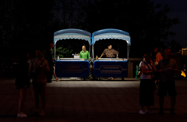 People walk as street vendors sell ice cream at the  Vorobyovy Gory (Sparrow Hills) viewpoint in Moscow, Russia on July 24, 2024. (Photo by Maxim Shemetov/Reuters)