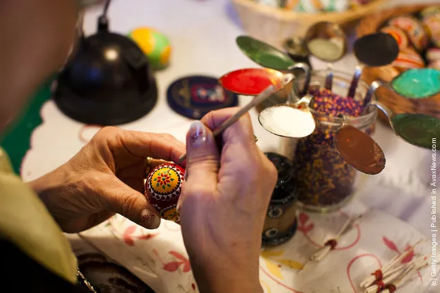 Sigrid Bolduan from the village Klein Loitz, wearing a traditional Lusatian sorbian folk dress, paints an Easter egg in traditional Sorbian motives at the annual Easter egg market