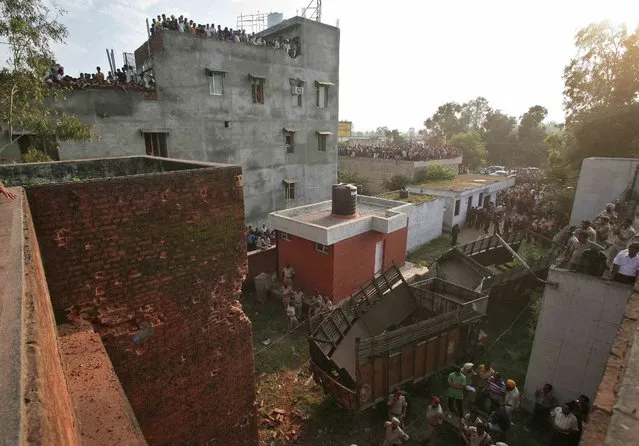 Onlookers look at the site of a gunfight in Dinanagar town in Gurdaspur district of Punjab, India, July 27, 2015. (Photo by Munish Sharma/Reuters)