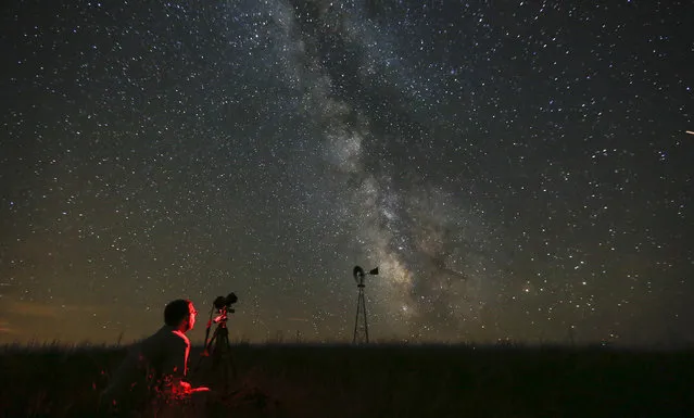 In this Wednesday, July 23, 2014 file photo, Omaha photographer Lane Hickenbottom photographs the night sky in a pasture near Callaway, Neb. With no moon in the sky, the Milky Way was visible to the naked eye. More than one-third of the world’s population can no longer see the Milky Way because of man-made lights, according to a scientific paper by Light Pollution Science and Technology Institute's Fabio Falchi and his team members, published on Friday, June 10, 2016. (Photo by Travis Heying/The Wichita Eagle via AP Photo)