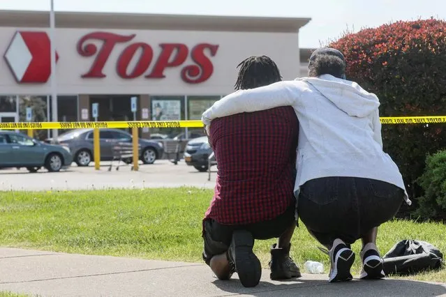 Mourners react while attending a vigil for victims of the shooting at a TOPS supermarket in Buffalo, New York, U.S. May 15, 2022. (Photo by Brendan McDermid/Reuters)
