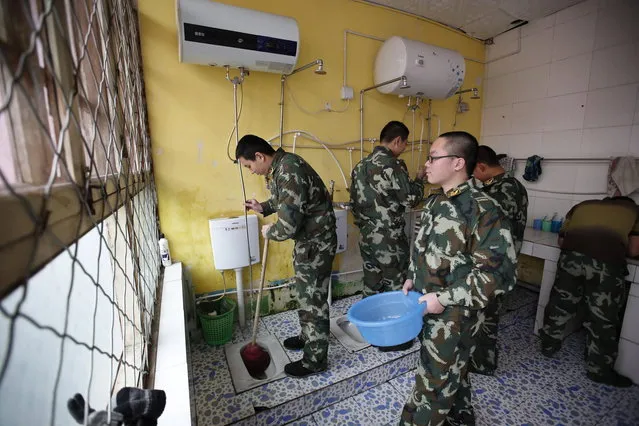 Wang (L), who was addicted to internet gaming, helps clean a bathroom in his dormitory at the Qide Education Center in Beijing February 19, 2014. The Qide Education Center is a military-style boot camp which offers treatment for internet addiction. (Photo by Kim Kyung-Hoon/Reuters)