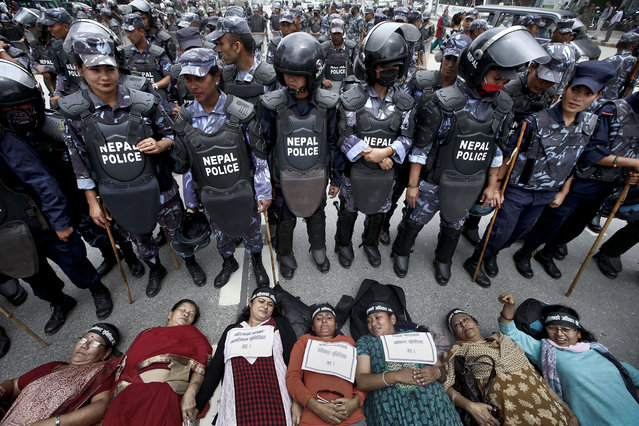 Nepalese women activists lie down on a road during a protest demanding women rights in upcoming constitution in Kathmandu, Nepal, August 7, 2015. According to reports, several groups are calling for women's rights to be enshrined in the new charter. A new charter was one of the provisions in the 2006 peace accord that ended the civil war in Nepal. (Photo by Narendra Shrestha/EPA)