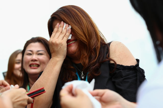 Turf club employees weep as the final horse race concludes, on the last day of operations at the Singapore Turf Club, in Kranji, Singapore on October 5, 2024. (Photo by Edgar Su/Reuters)