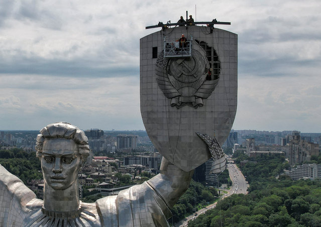 Workers dismount a Soviet emblem from the shield of the “Motherland” monument, amid Russia's attack on Ukraine, at a compound of the World War II museum in Kyiv, Ukraine on July 30, 2023. (Photo by Valentyn Ogirenko/Reuters)