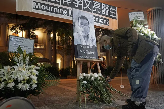 A man wearing mask, attends a vigil for Chinese doctor Li Wenliang, in Hong Kong, Friday, February 7, 2020. The death of a young doctor who was reprimanded for warning about China's new virus triggered an outpouring Friday of praise for him and fury that communist authorities put politics above public safety. (Photo by Kin Cheung/AP Photo)