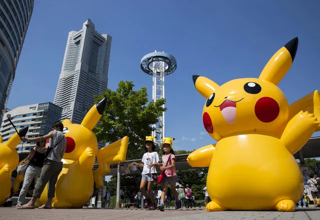 Girls walk near balloons of Pikachu, a character from Pokemon series game titles, during the Pikachu Outbreak event hosted by The Pokemon Co. on August 9, 2017 in Yokohama, Kanagawa, Japan. (Photo by Tomohiro Ohsumi/Getty Images)
