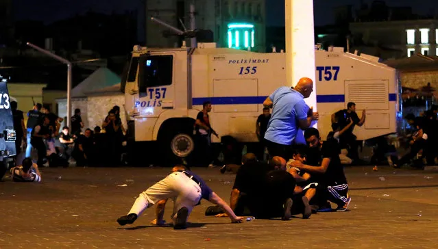 People take cover near policemen as gunfire are heard during an attempted coup in Istanbul's Taksim Square, Turkey, July 16, 2016. (Photo by Murad Sezer/Reuters)