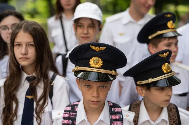 Young conductors stand in line during the steam locomotive presentation at the Kyiv Children's Railway Station on July 3, 2022 in Kyiv, Ukraine. According to the railway's operators, the Gr-336 locomotive was built in Germany in 1951 and brought to Kyiv as part of reparations in the wake of World War II. (Photo by Alexey Furman/Getty Images)