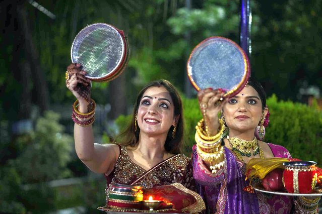 Married Hindu women look at the moon through a sieve as part of a ritual to break her fast during Karva Chauth festival in Jammu, India, Sunday, October 20, 2024. (Photo by Channi Anand/AP Photo)