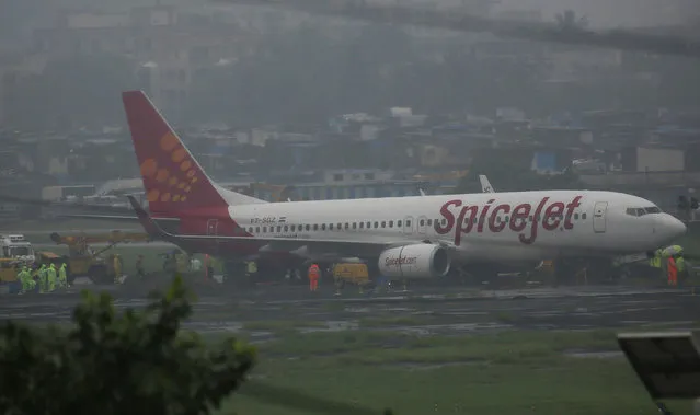 A domestic Spice Jet aircraft is seen off the runway after it skidded off into the unpaved surface during heavy rains in Mumbai, India, Wednesday, September 20, 2017. (Photo by Rafiq Maqbool/AP Photo)