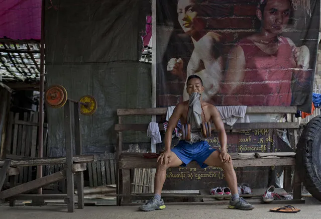 In this Wednesday, July 15, 2015, photo, a member of the White New Blood lethwei fighters club, a Myanmar traditional martial-arts club which practices a rough form of kickboxing, practices strengthening exercises during a practice session at their gym on a street in Oakalarpa, north of Yangon, Myanmar. (Photo by Gemunu Amarasinghe/AP Photo)