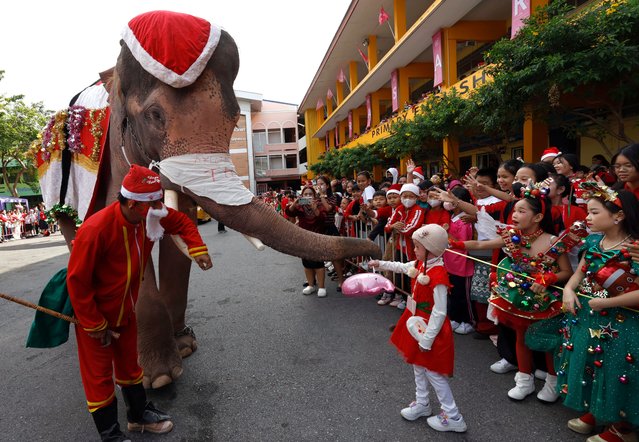 A Thai mahout and elephant, both dressed as Santa Claus, distribute gifts to students during a Christmas celebration at Jirasartwitthaya School in the world heritage city in Ayutthaya, Thailand, 24 December 2024. The annual event is held to celebrate the Christmas festive season and to promote tourism in Ayutthaya. (Photo by Rungroj Yongrit/EPA/EFE)