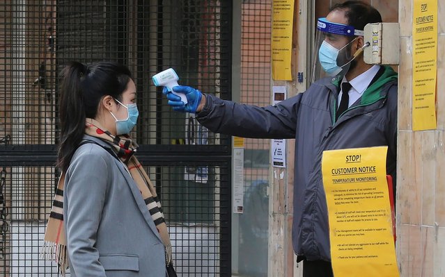 A security guard uses a handheld scanner to take the temperature of a customer wanting to enter an Asian supermarket in the Chinatown district of London on May 13, 2020, as life in Britain continues during novel coronavirus pandemic. Britain implemented its COVID-19 lockdown – which is only just starting to be slowly eased – on March 23. Britain's economy shrank in the first quarter at the fastest pace since the 2008 financial crisis as the country went into lockdown over the coronavirus, official data showed Wednesday, leaving it on the brink of recession with a far worse contraction to come. (Photo by Isabel Infantes/AFP Photo)