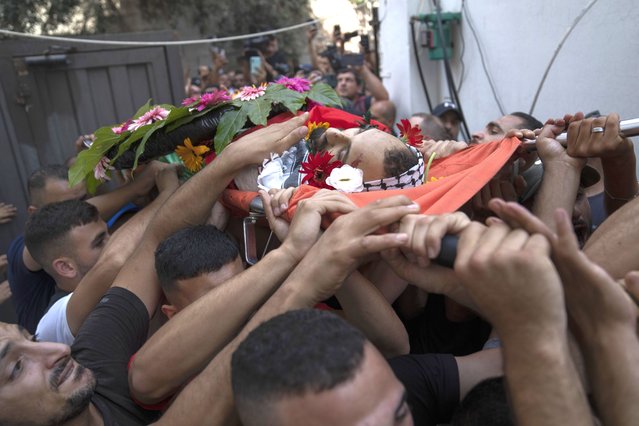 Mourners carry the body of Yazan Afaneh, 26 years old, who was shot and killed by Israeli forces during clashes following an army raid in the town of al Bireh, during his funeral in the West Bank refugee camp of Qalandia, north of Ramallah Thursday, September 1, 2022. Afaneh and another Palestinian were killed during separate Israeli army operations in the West Bank, which raises the total number of killed Palestinians to 140 since the beginning of 2022, Palestinian health ministry said. (Photo by Nasser Nasser/AP Photo)