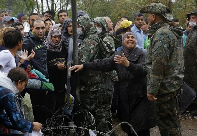 A Syrian refugee woman begs a Macedonian soldier to allow members of her family to cross to her side at Greece's border with Macedonia, near the Greek village of Idomeni, September 10, 2015. (Photo by Yannis Behrakis/Reuters)