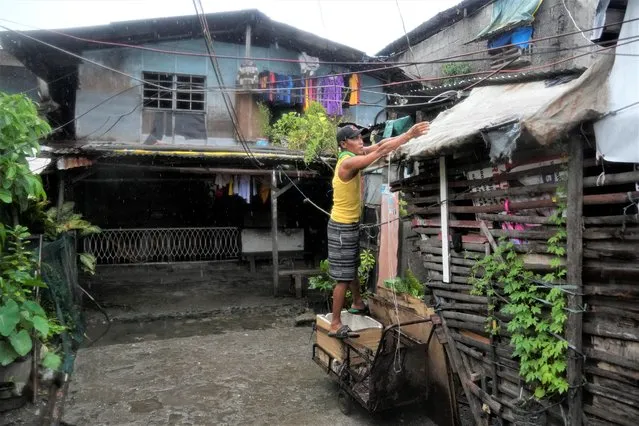 A resident secures his roof as Typhoon Noru approaches the seaside slum district of Tondo in Manila, Philippines, Sunday, September 25, 2022. (Photo by Aaron Favila/AP Photo)
