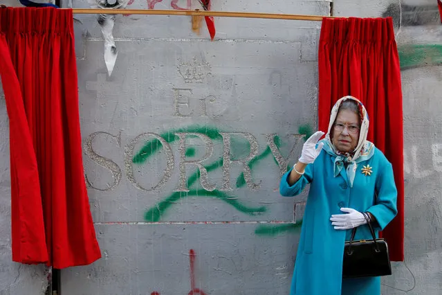 A person, dressed as Britain's Queen Elizabeth II, gestures during an event ahead of the anniversary of the Balfour Declaration, outside Banksy's Walled Off Hotel in the West Bank city of Bethlehem November 1, 2017. (Photo by Mussa Qawasma/Reuters)