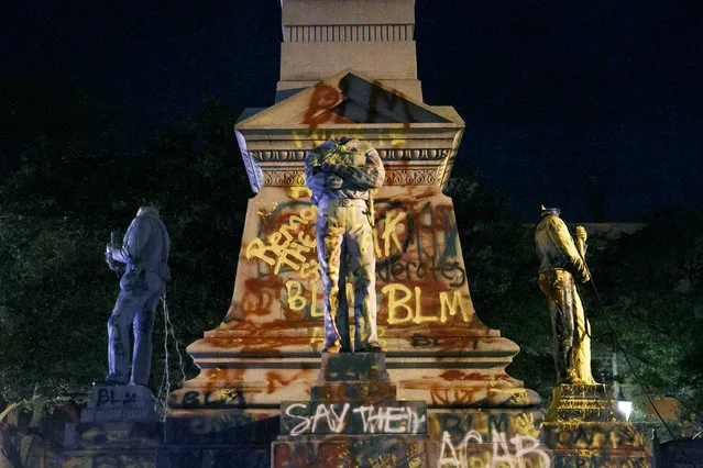 The statues on the Confederate monument are covered in graffiti and beheaded after a protest  in Portsmouth, Va., Wednesday,  June 10, 2020. Protesters beheaded and then pulled down four statues that were part of a Confederate monument.  The crowd was frustrated by the Portsmouth City Council’s decision to put off moving the monument. (Photo by Kristen Zeis/The Virginian-Pilot via AP Photo)