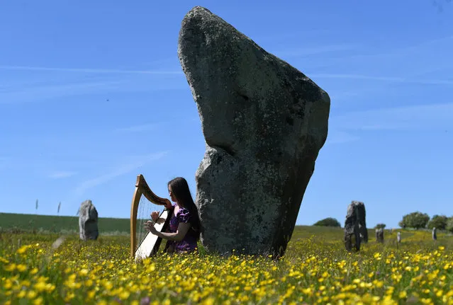 Rosie Foy practices the harp by the ancient stone monuments in Avebury, Britain, 19 May 2020. Britain's Prime Minister Boris Johnson continues to ease the lockdown after weeks of measures to stem the spread of the pandemic COVID-19 disease caused by the SARS-CoV-2 coronavirus. There is no longer a limit on how far people can travel and people are allowed to meet one person outside their household. People are still urged to think twice about travelling amid fears of a second ride of the coronavirus. (Photo by Neil Hall/EPA/EFE)