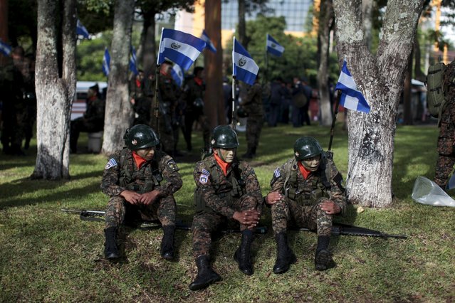 Salvadoran soldiers rest prior to participating in the parade commemorating Independence Day in San Salvador, El Salvador, September 15, 2015. El Salvador gained independence from Spain on September 15, 1821. (Photo by Jose Cabezas/Reuters)