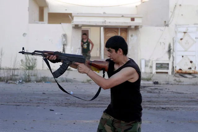 A fighter from Libyan forces allied with the U.N.-backed government aims his weapon during a battle with Islamic State fighters in Sirte, Libya August 21, 2016. (Photo by Hani Amara/Reuters)