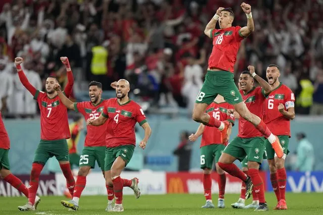 Morocco's Jawad El Yamiq, top, celebrates with team mates after the penalty shootout at the World Cup round of 16 soccer match between Morocco and Spain, at the Education City Stadium in Al Rayyan, Qatar, Tuesday, December 6, 2022. (Photo by Luca Bruno/AP Photo)