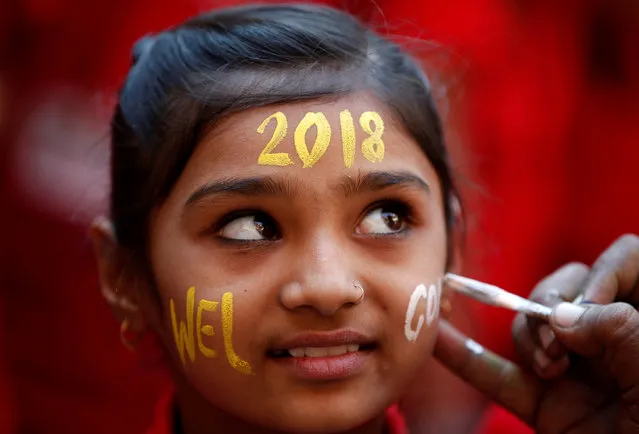 A schoolgirl reacts as she gets her face painted during celebrations to welcome the New Year at her school in Ahmedabad, India, December 30, 2017. (Photo by Amit Dave/Reuters)