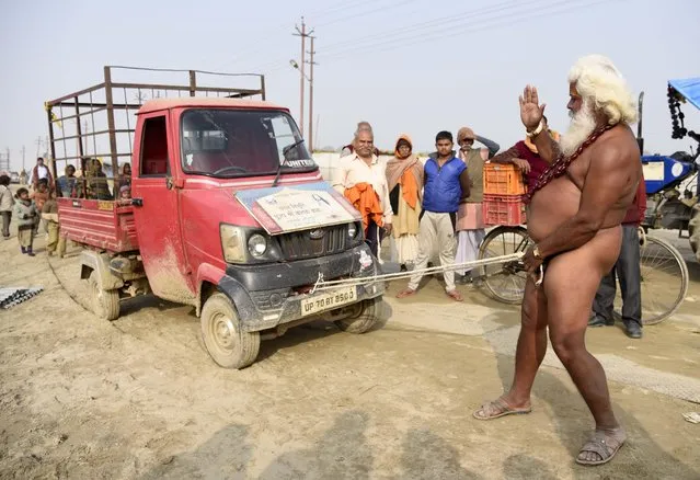 A naked holy man pulls a vehicle using his pen*s during the Magh mela festival in Allahabad, India on January 3, 2018. (Photo by Prabhat Kumar Verma/ZUMA Wire/Rex Features/Shutterstock)