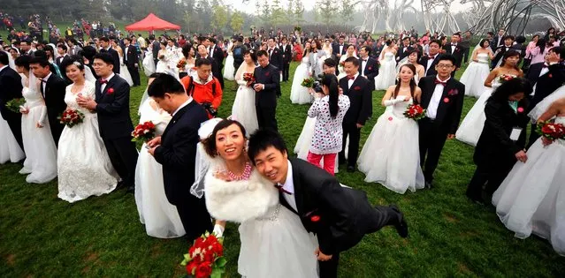 Two hundred newlywed couples pose at the National Stadium, better known as the Bird's Nest, in Beijing.   (Photo by AFP Photo)