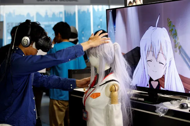 A man touches a mannequin as he tries out a M2 Co.Ltd's “E-mote” system as the monitor shows the image from the VR device at Tokyo Game Show 2016 in Chiba, east of Tokyo, Japan, September 15, 2016. (Photo by Kim Kyung-Hoon/Reuters)